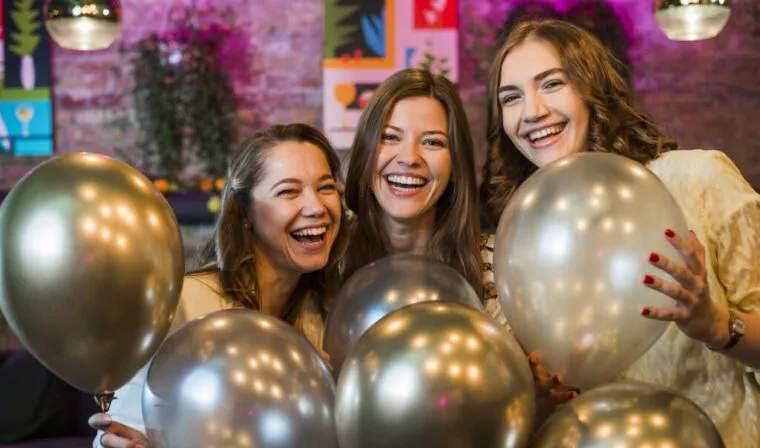 Trzy przyjaciółki z balonami na imprezie urodzinowej