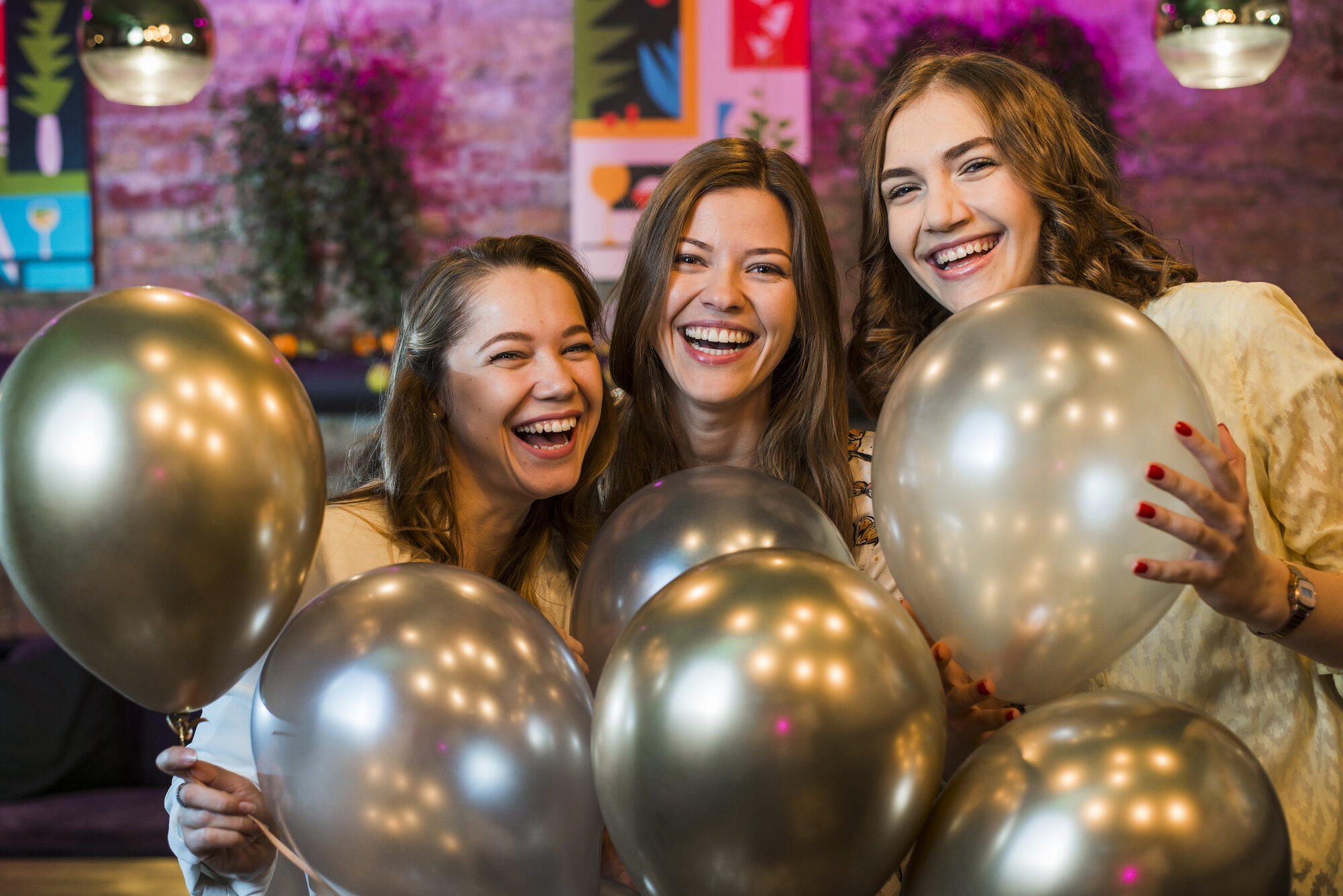 Trzy przyjaciółki z balonami na imprezie urodzinowej