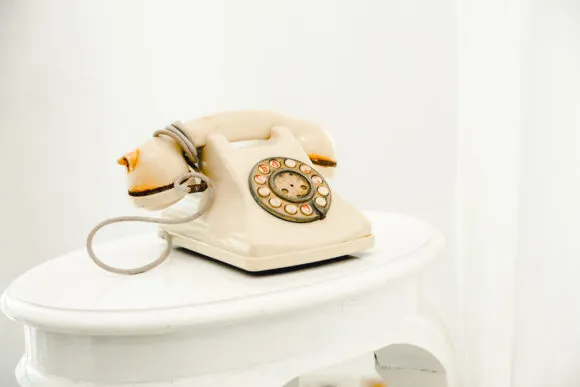 Kremowy telefon retro na białym stoliku